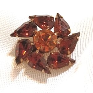 Vintage brown and amber pinwheel style rhinestone brooch.